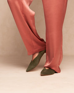 Model in pink satin trousers wearingOya Ramona flat pointed toe shoe in olive green suede, low heel for extended women's sizes, luxury look.