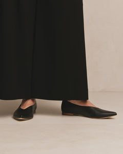 Video clip of model wearing wide leg trousers withOya Ramona flat pointed toe classic black nappa leather shoes, low heel and made in large women's sizes, perfect work shoe.